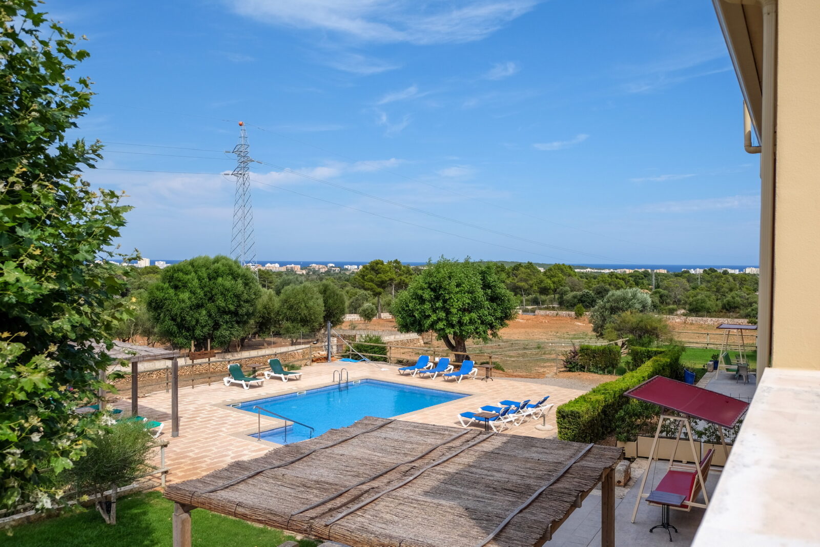 Poolterrasse mit Hollywoodschaukel und Sonnenschutz