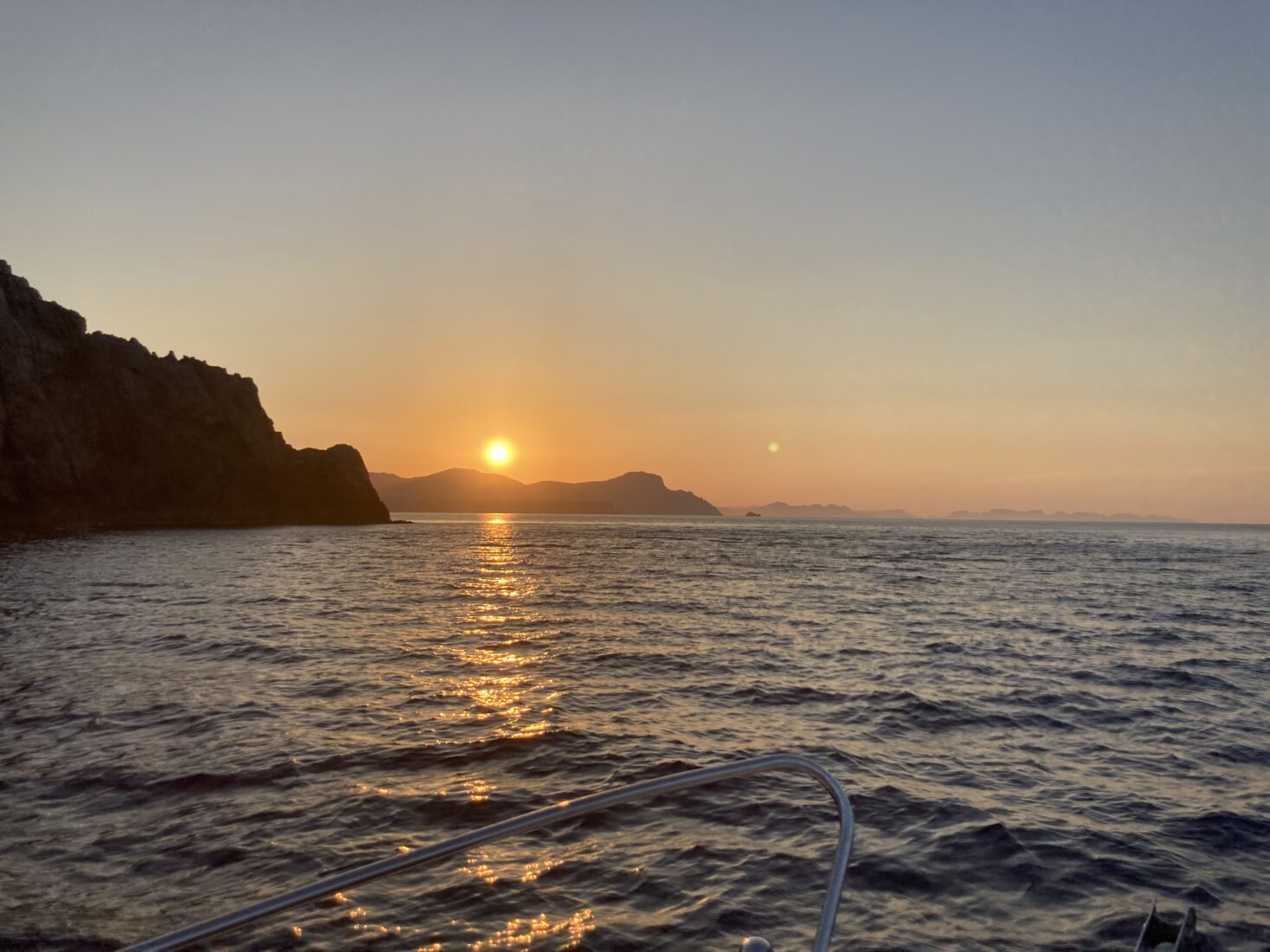 Sonnenuntergang vom Boot aus mit Blick auf die Cala Mesquida