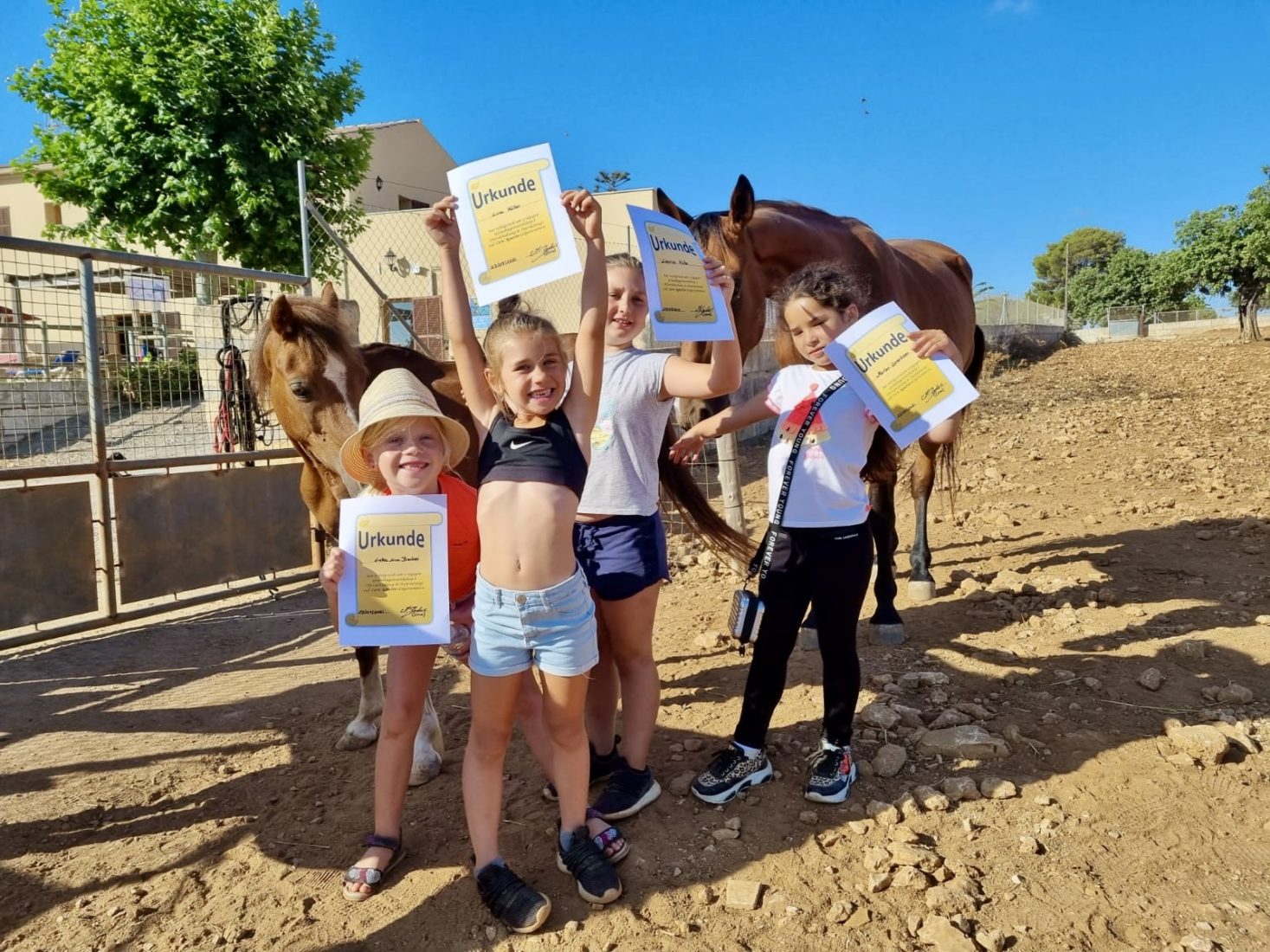 Ferienkinder im Reitercamp zeigen stolz die Pferdeführerschein Urkunde