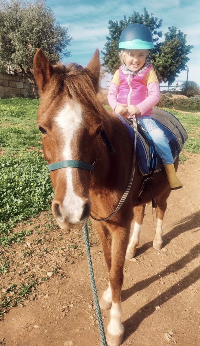 Ein kleines Mädchen reitet auf unserem Pony Libby
